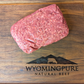 Raw ancestral ground beef with organ meat on a wooden cutting board with Wyoming Pure Natural Beef logo.